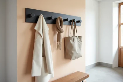 Porte-manteau mural en métal noir mat dans une entrée scandinave minimaliste avec banc en chêne et mur blanc texturé